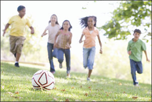 School age children playing soccer